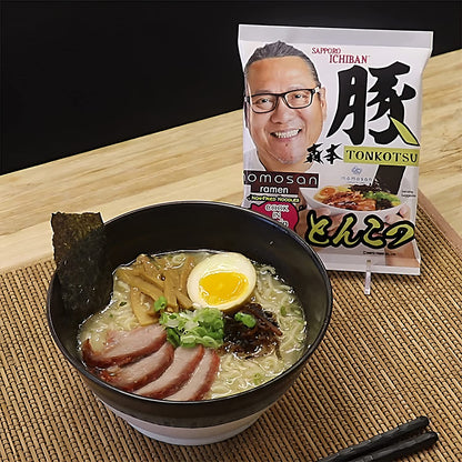 Bowl of ramen with a package of Sapporo Ichiban Tonkotsu ramen on a wooden surface.